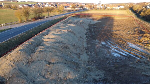Luftbild des künftigen Supermarkt-Standorts in Großrinderfeld mit Erdaufschüttungen, unbebaut.