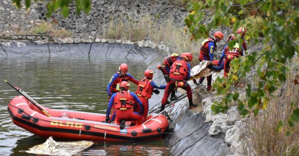 DLRG-Einsatzkräfte üben mit einem Schlauchboot und einer Leiter die Personenrettung am Löschwasserteich